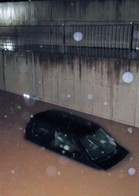 車体の半分が水に漬かった車＝７日午前１時３３分、豊岡市九日市下町