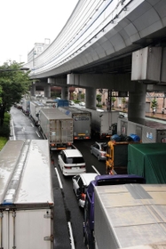 大雨の影響で高速道路で通行止めが相次ぎ、トラックなどの車で渋滞する国道２号＝７日午前８時２５分、神戸市中央区東川崎町