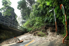 崩れた土砂でふさがれた道路＝６日午前８時４６分、神戸市東灘区鴨子ケ原２（撮影・吉田敦史）