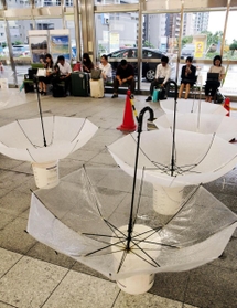 山陽新幹線の運行再開を待つ乗客らの前に、雨漏りを受け止める傘がいくつも広げられた＝６日午前９時３１分、ＪＲ新神戸駅（撮影・山崎　竜）