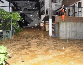 道まで流れ出た土砂。消防署員らが非難を呼びかけた＝７日午前０時５分、神戸市灘区篠原台