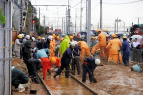 線路に入った土砂の取り除き作業を続ける作業員＝６日午後５時４８分、神戸市垂水区塩屋町（撮影・大山伸一郎）