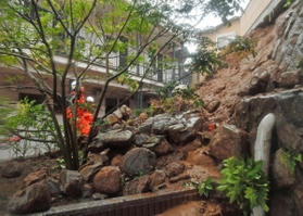 大雨の影響で起きた土砂崩れの現場を確認する消防隊員＝５日午後、神戸市中央区中尾町（撮影・後藤亮平）