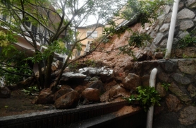 大雨の影響で崩れた住宅裏の土砂＝５日午後０時５５分、神戸市中央区中尾町