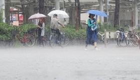 路面に激しく雨が打ち付ける中、傘を差して歩く人ら＝５日午前９時３８分、ＪＲ神戸駅前（撮影・大森　武）