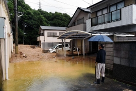 流入した土砂を見つめる住民＝７日午前８時４１分、神戸市灘区篠原台