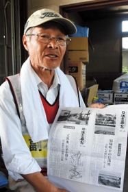 明治時代に下原地区であった水害を記した新聞記事を手に、住民の避難活動を振り返る川田一馬さん＝岡山県総社市下原
