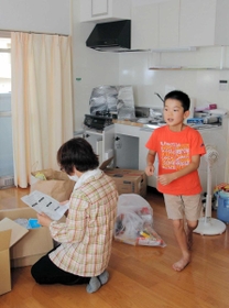 被災者に無償で提供された公営住宅で新しい生活の準備をする毛利有香さんと陽平君＝６日午後、広島県坂町小屋浦