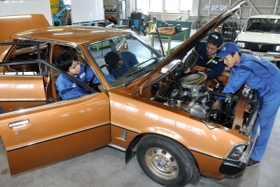 旧車の修復作業に当たる日本工科大学校の学生ら＝姫路市兼田