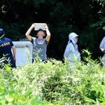 作業員が流された排水管の出口付近を調べる捜査員＝１０日午前１１時４８分、猪名川町差組