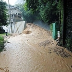 土石流が発生する前に道路を茶色い水が流れた＝６日午後３時３５分、神戸市灘区篠原台（住民提供）