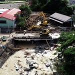 流木が川をせき止めたため、重機を使って進む撤去作業＝９日午後４時３６分、宍粟市一宮町河原田
