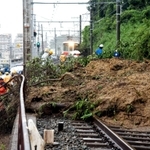 土砂で埋まった山陽塩屋－須磨浦公園間の線路。奥は立ち往生した山陽電鉄の特急電車＝６日午後、神戸市垂水区塩屋町１