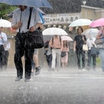 たたきつけるような雨の中、傘を差して歩く人たち＝５日午前、神戸市中央区