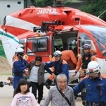 大雨で孤立した集落からヘリコプターで救助され、近くの中学校へ降り立った被災住民＝８日午前１１時２９分、兵庫県宍粟市、一宮北中学校（撮影・小林良多）