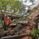 大雨の影響で起きた土砂崩れの現場を確認する消防隊員＝５日午後、神戸市中央区中尾町（撮影・後藤亮平）