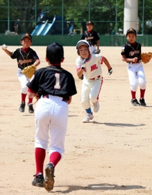 ランナーを挟むけやき坂グリーンファイターズの選手たち＝西宮中央運動公園野球場