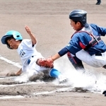 決勝の１回、内野ゴロの間に間一髪で生還した市場スポーツ少年団の佐々木叶翔選手＝西脇公園野球場
