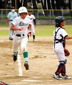 １回戦　北脇野球部－二見フレンズジュニア　内野ゴロの間に生還する北脇野球部の選手＝浜の宮公園グラウンド