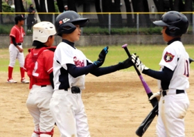 準決勝　二見フレンズジュニア－野口南少年軟式野球クラブ　本塁に生還し、仲間と喜び合う二見フレンズジュニアの選手＝浜の宮公園グラウンド