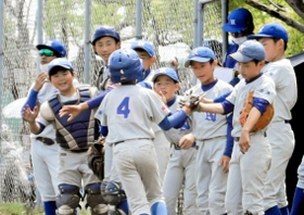 生還したランナーを笑顔で迎える西脇野球スポーツ少年団の選手ら＝大池総合公園野球場