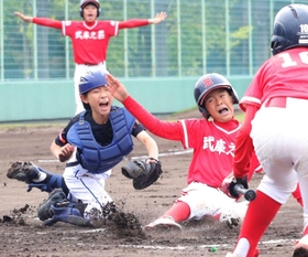 本塁に滑り込む選手＝甲子園浜野球場