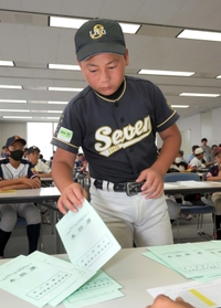 組み合わせ番号札が入った封筒を引く選手＝神戸市中央区、神戸新聞社（撮影・風斗雅博）