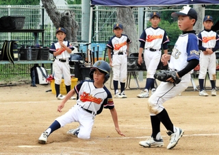 本塁に滑り込む志筑少年野球団の選手
