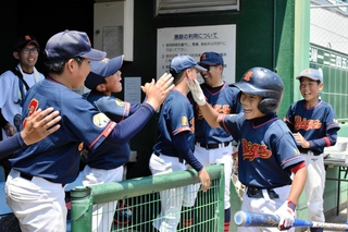 決勝の１回裏、先制のホームを踏み、仲間から祝福を受けるくるみビックスの中塚琳乃助選手（右から２人目）