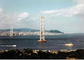 明石海峡にそびえ立つ高さ約３００メートルの主塔。周囲を行き交う船がその巨大さをよく表している（１９９３年６月）