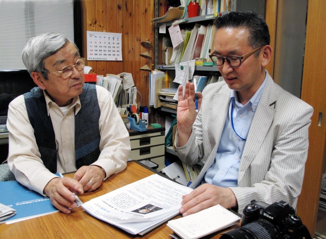 脱線事故について尹記者（右）から取材を受ける遺族の浅野さん＝尼崎市内