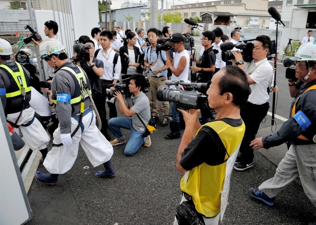 マンションの解体工事現場に入る作業員ら。遺族の上田弘志さん（手前）が記録用のビデオを構える＝２７日午前、尼崎市久々知（撮影・三津山朋彦）