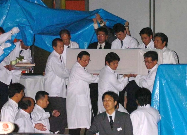 運び出される犠牲者の棺＝尼崎市記念公園総合体育館