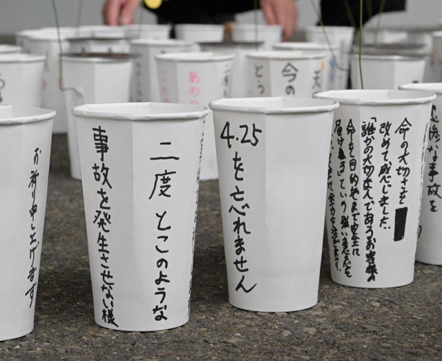 「４・２５を忘れません」などの言葉が書かれた紙コップ＝２４日午後、尼崎市久々知３（撮影・秋山亮太）