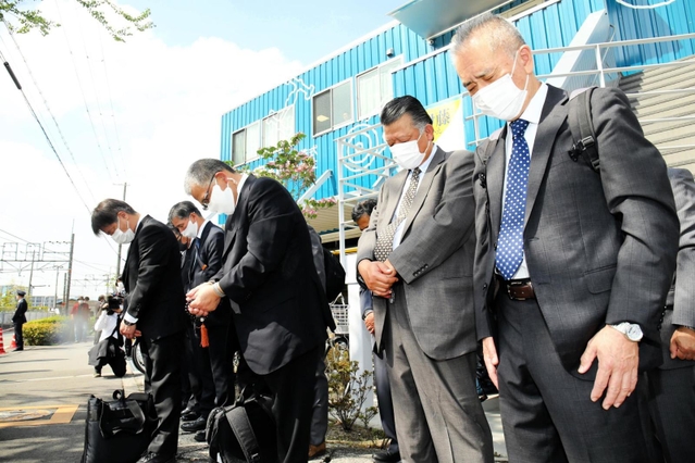 事故現場に向かって黙とうするＪＲ西日本の労働組合のメンバーら＝２５日午前９時１８分、尼崎市久々知西町２（撮影・山崎　竜）