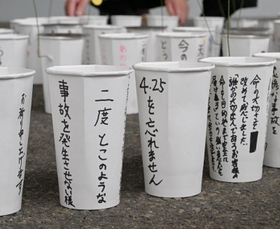 「４・２５を忘れません」などの言葉が書かれた紙コップ＝２４日午後、尼崎市久々知３（撮影・秋山亮太）