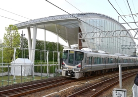 脱線事故現場の前を通過する列車＝２５日午前７時１６分、尼崎市久々知３（撮影・中西幸大）