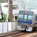 事故現場を通過する列車。会場は目隠しの布で覆われる中、車内の車掌が黙礼していた＝２５日午前７時５４分、尼崎市久々知３（撮影・中西幸大）