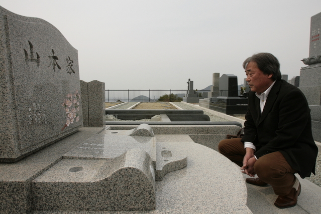 納骨前の墓石に向き合う。遠く、妻と暮らした町が見下ろせる＝西宮市内（撮影・大山伸一郎）