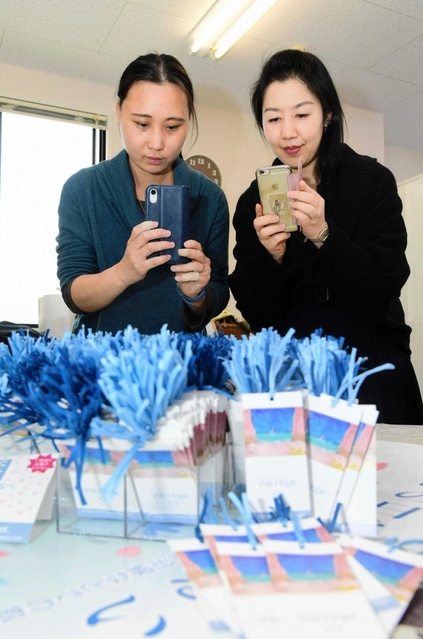 福田裕子さん（左）がイラストを手掛けた「空の栞」の完成品を前に、記念撮影する福田さんと木村仁美さん＝川西市小花１（撮影・中西幸大）