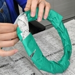 （１）新聞紙を細長く丸め、両端をセロハンテープでとめて輪にする。緑や黄緑の折り紙を短冊状に切り、輪に巻き付けながら貼る