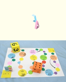 （上）◇コマ　色画用紙を短冊状に切り、折り目をつけて細長い直立する形を作り、端をテープで留める。好きな絵を描く（下）完成したすごろく