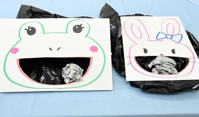 【２】画用紙を裏返し、口の周囲にごみ袋をテープでとめる。紙吹雪にした新聞紙を丸め、口を目がけて放り投げよう