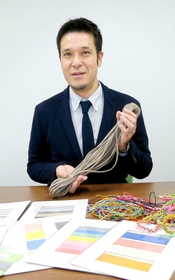 糸ゴムを使った製品の数々。丸山高史社長が手に持つ太いソバのようなゴムが、害鳥駆除用のパチンコに使われるという＝いずれも硯町３