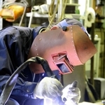 熟練の技で金属を加工する社員＝明石市大久保町江井島