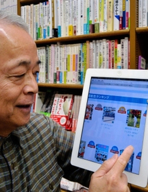 タブレット端末でグループのネット事業「ｈｏｎｔｏ」のサイトを利用する工藤恭孝社長＝神戸市中央区三宮町１、ジュンク堂書店三宮店（撮影・後藤亮平）