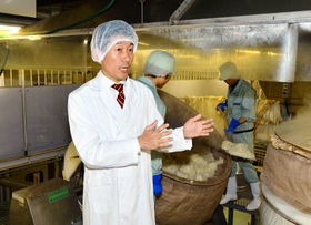 「データ化を進めても、昔ながらの仕込み方は変えない」と話す安福武之助社長。後ろでは、社員が蒸し上がった米を手作業で取り出していた＝神戸市東灘区御影塚町１、神戸酒心館（撮影・後藤亮平）