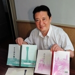 神戸ノート「百字練習帳」「れんらくちょう」を前にする大河裕二・関西ノート相談役と、それぞれの表紙に使われた写真＝神戸市長田区浪松町