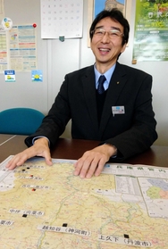 県の支援を受けて小水力発電事業に取り組む地域を地図で示す小塩浩司さん＝県庁