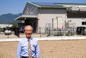太陽光発電装置を設置した学校給食センターと齋藤周藏さん。「環境学習にも活用してもらいたい」＝西脇市上戸田